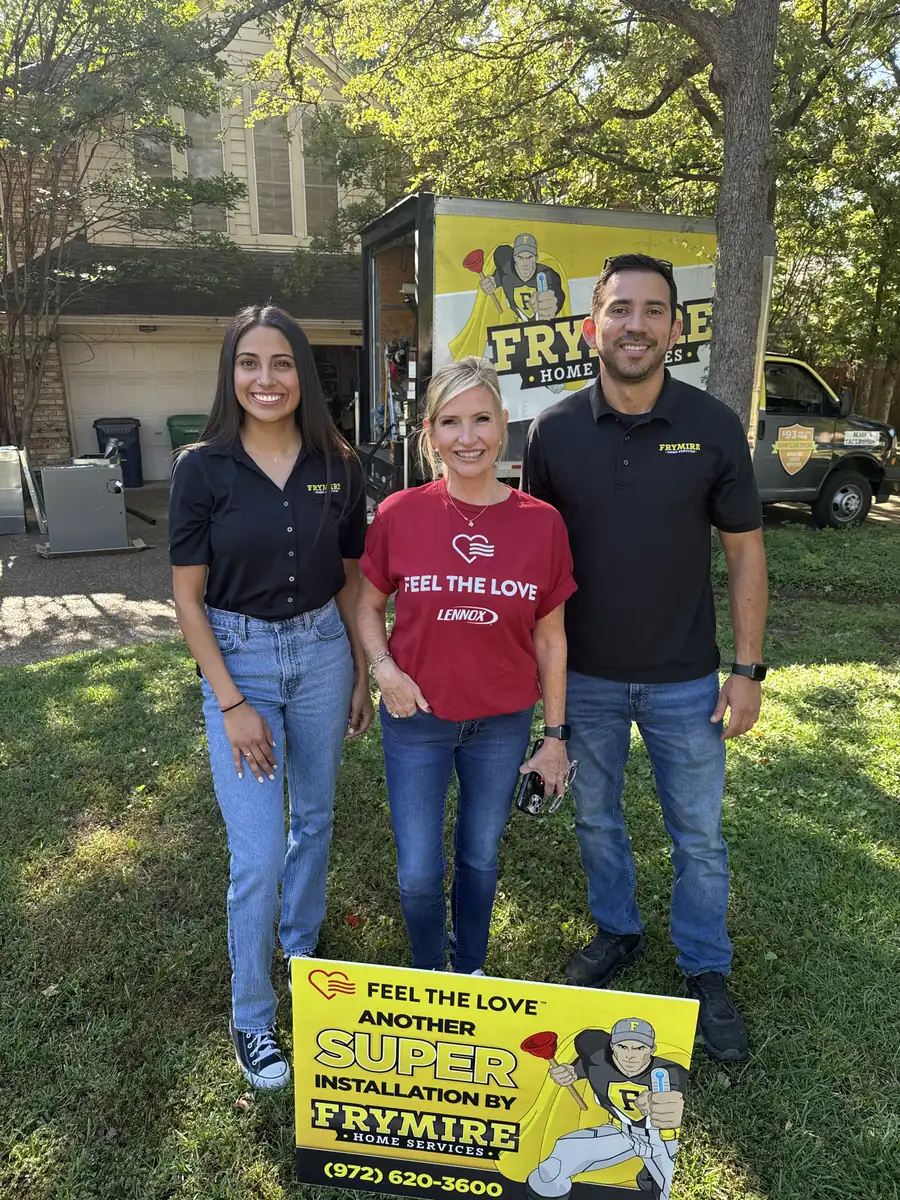 Frymire team members smiling with a Feel the Love yard sign at the completed installation