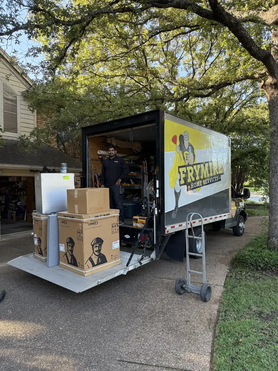 Frymire Home Services box truck parked in a driveway with new HVAC equipment on a hand truck