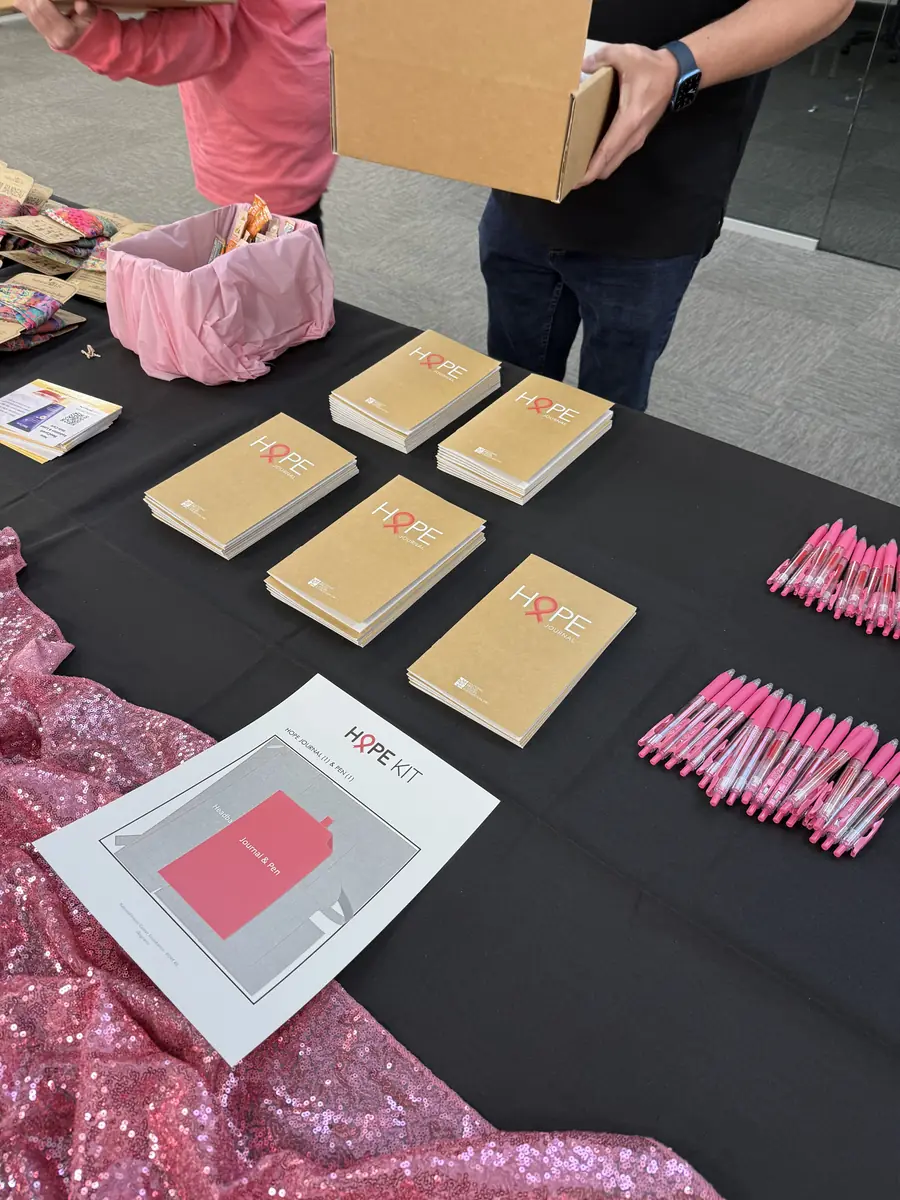 Team members filling HOPE Kit boxes with care items at a packing table