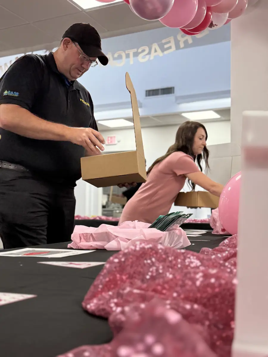 Two Frymire employees packing comfort items into HOPE Kit boxes at the event