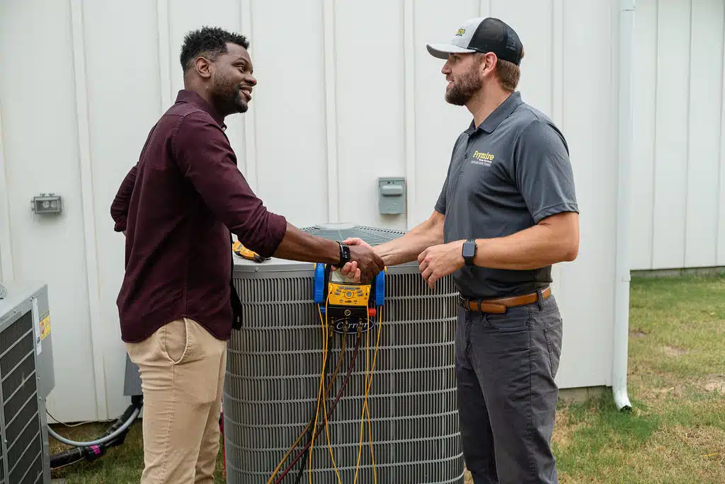 Frymire employee shaking hands with customer after water heater repair in Dallas, TX.