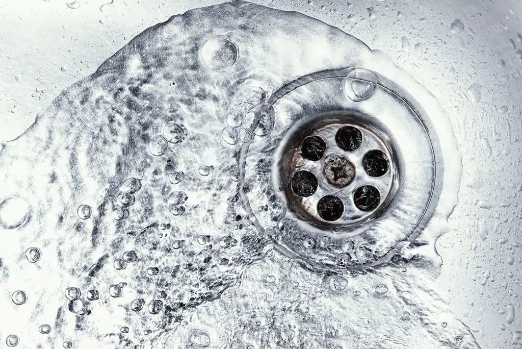 Water going down a stainless steel sink drain.