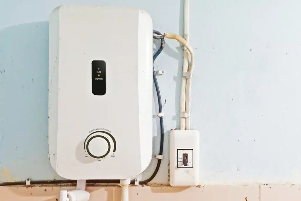 White tankless water heater installed on a pale blue/white wall.