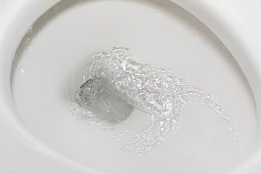 Toilet bowl with clean toilet water making its way down the drain following a quick flush